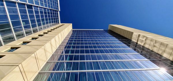 Low angle view of modern building against clear blue sky