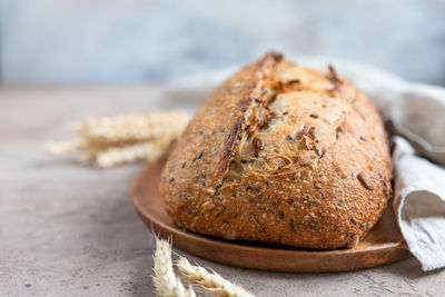 Loaf of artisan sourdough bread with wheat ears and linen napkin. tartine with multigrain seeds.