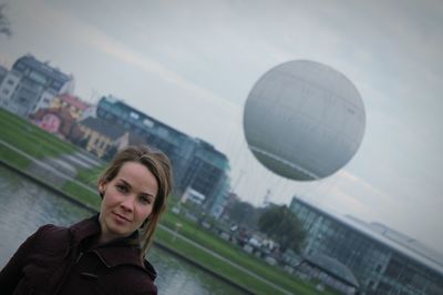 Portrait of young woman hot air balloon in city