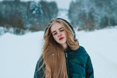 Portrait of young woman standing on snow