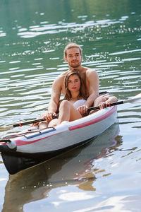 Portrait of couple sitting in boat on lake