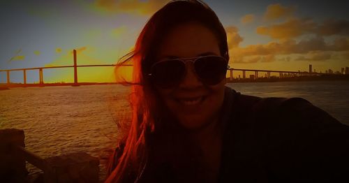 Portrait of man wearing sunglasses at beach during sunset