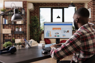 Rear view of man working at office