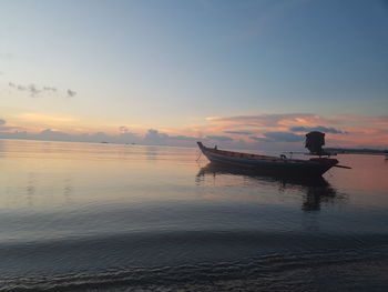 Silhouette boat in sea against sky during sunset