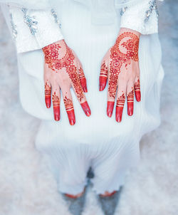 Low section of bride with henna tattoo on hands