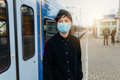 Portrait of man standing on train at railroad station