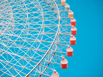 Low angle view of ferris wheel against blue sky