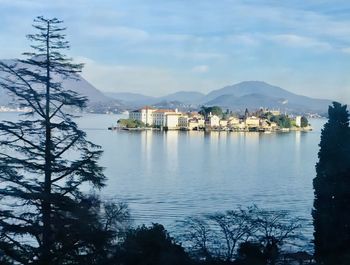 Scenic view of lake by buildings against sky