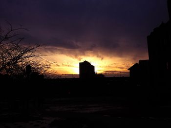 Silhouette of buildings against sky at sunset