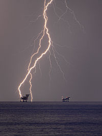 Lightning over the petrol platforms in the sea