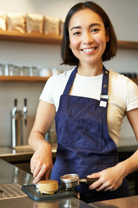 Portrait of smiling young woman sitting on table