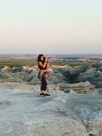 Full length of man on rock against clear sky