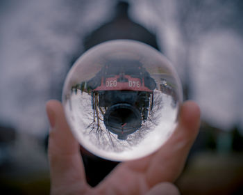 Close-up of hand holding crystal ball