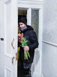 Man holding bouquet and standing at doorways