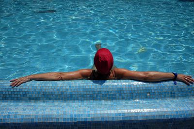 Rear view of man swimming in pool