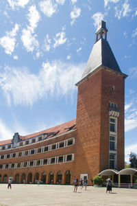 People in front of building against sky