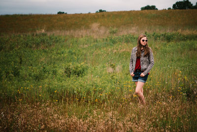 Portrait of young woman standing on field