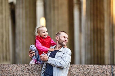 Rear view of father and daughter outdoors