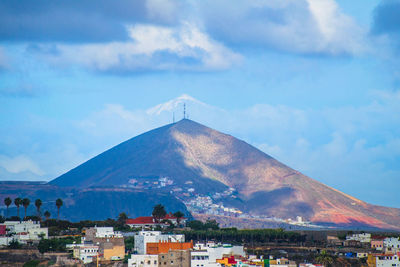 Buildings in city against cloudy sky
