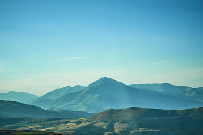 Scenic view of mountains against blue sky