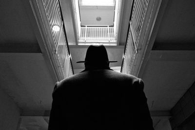Rear view of man standing against building
