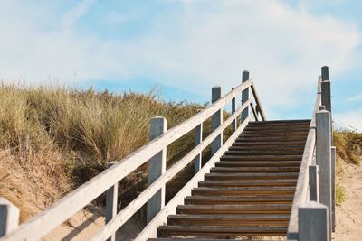 Staircase on beach against sky