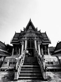 Low angle view of temple and building against clear sky
