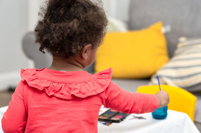 Midsection of boy holding yellow at home