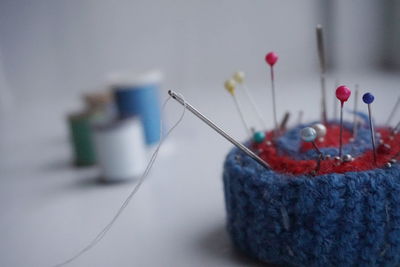 Close-up of pin cushion with colorful pins on table