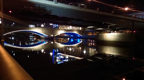 Illuminated bridge over canal at night