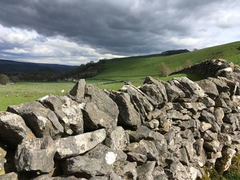 Rocks on field against sky