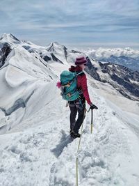 Rear view of person on snowcapped mountain