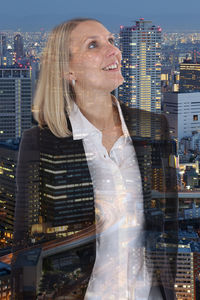 Woman looking at cityscape against buildings in city