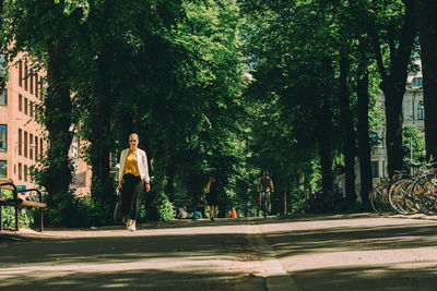 People walking by trees in city