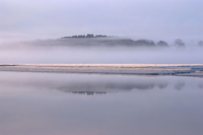 Scenic view of lake against sky during winter