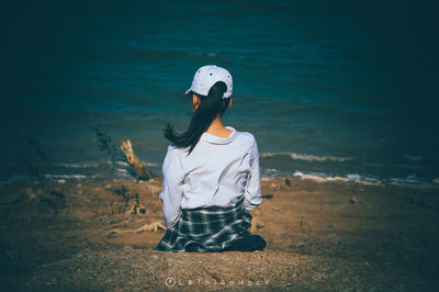 Rear view of woman standing on shore