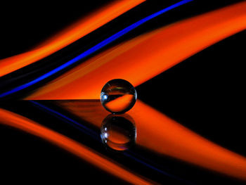 Close-up of water drops on glass against black background