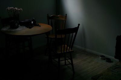 Empty chairs and table against wall at home