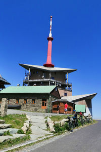 Lighthouse against buildings in city against clear blue sky