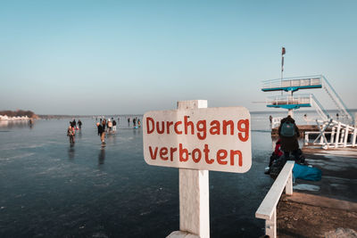 People on beach against clear sky