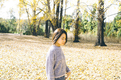 Woman standing on leaves in park during autumn