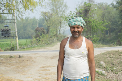 Portrait of smiling man standing on road at village