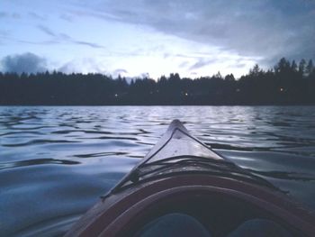 Boats in calm lake at sunset