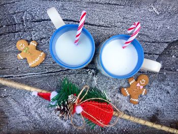 Directly above shot of drinks with gingerbread cookies on table