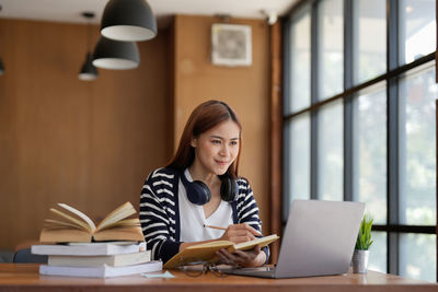 Young woman using laptop at table