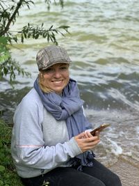 Portrait of smiling young woman using mobile phone in water