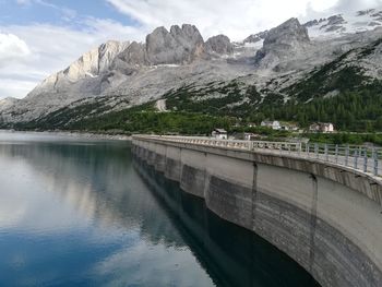 Scenic view of lake by mountains against sky