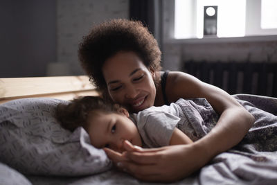 Mother and baby girl lying on bed