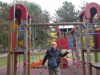 Full length of man standing by railing at playground