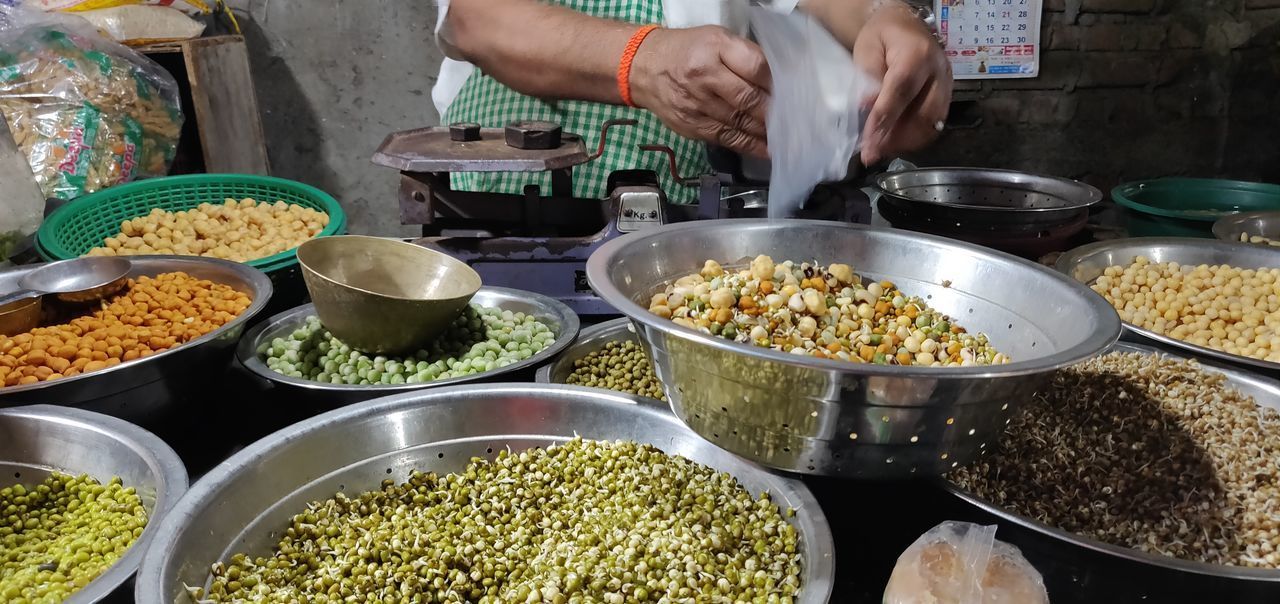 MIDSECTION OF WOMAN PREPARING FOOD AT MARKET